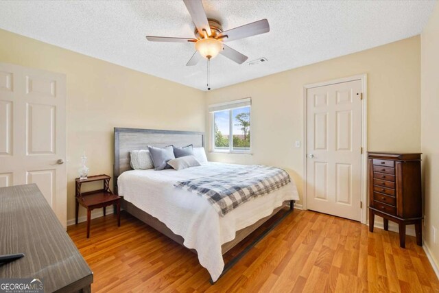 226 Bull River Bluff Dr, Savannah, GA 31410 - bedroom featuring light wood-style flooring, a textured ceiling, and ceiling fan