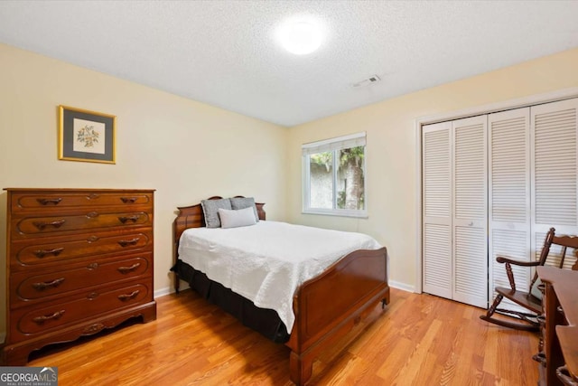 226 Bull River Bluff Dr, Savannah, GA 31410 - bedroom with light wood-style floors, a textured ceiling, a closet, and baseboards