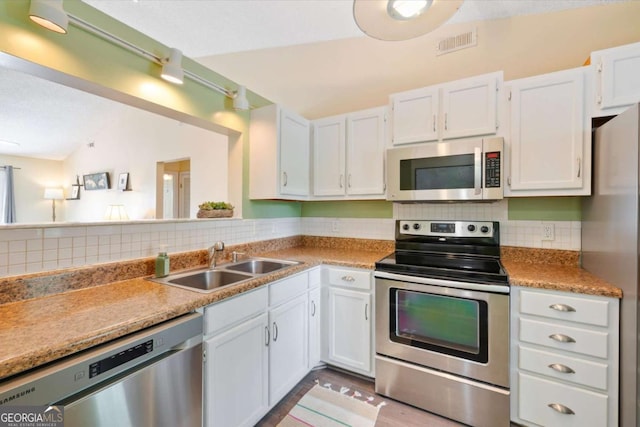 226 Bull River Bluff Dr, Savannah, GA 31410 - kitchen featuring appliances with stainless steel finishes, a sink, tasteful backsplash, white cabinets, and vaulted ceiling