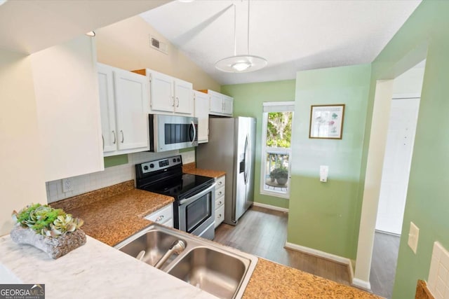 226 Bull River Bluff Dr, Savannah, GA 31410 - kitchen with appliances with stainless steel finishes, a sink, light wood-type flooring, tasteful backsplash, and white cabinetry