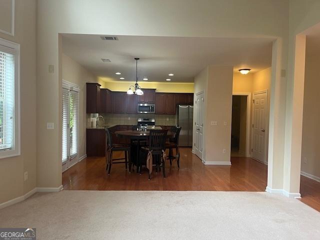 82 Sweetwater Way, Senoia, GA 30276 - carpeted dining area with healthy amount of natural light, a chandelier, baseboards, and recessed lighting