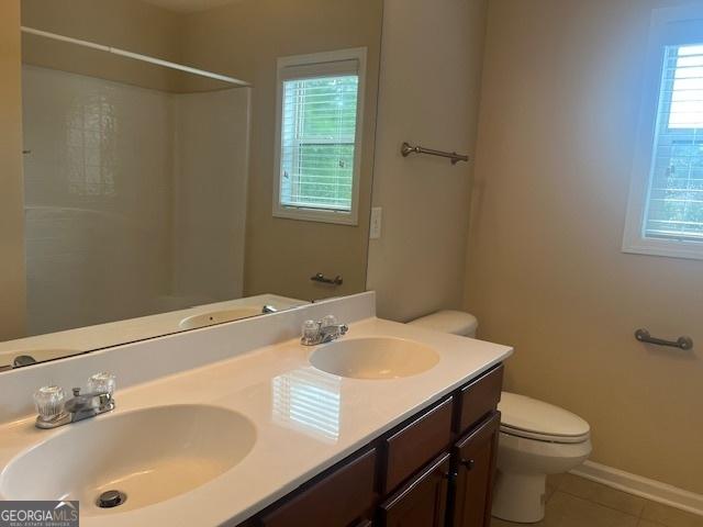 82 Sweetwater Way, Senoia, GA 30276 - full bathroom featuring toilet, double vanity, tile patterned flooring, a shower, and baseboards