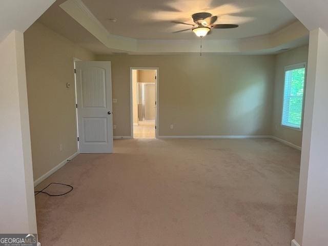 82 Sweetwater Way, Senoia, GA 30276 - spare room with a tray ceiling, ceiling fan, light carpet, and baseboards