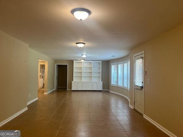 82 Sweetwater Way, Senoia, GA 30276 - unfurnished room with baseboards, dark tile patterned floors, and built in shelves