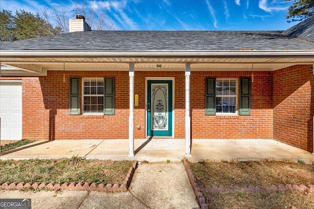 113 Elmwood Dr, Hampton, GA 30228 - doorway to property with brick siding, covered porch, and roof with shingles