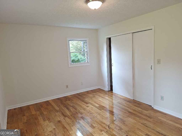 1261 Glenn Carrie Rd, Hull, GA 30646 - unfurnished bedroom featuring light wood-type flooring, a textured ceiling, a closet, and baseboards