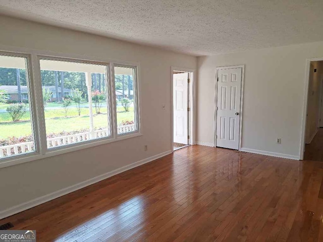 1261 Glenn Carrie Rd, Hull, GA 30646 - unfurnished living room featuring a textured ceiling, hardwood / wood-style flooring, and baseboards