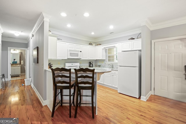 112 Gleneagle Ct Unit D202, Clayton, GA 30525 - kitchen with white appliances, white cabinetry, light wood-type flooring, a kitchen breakfast bar, and crown molding