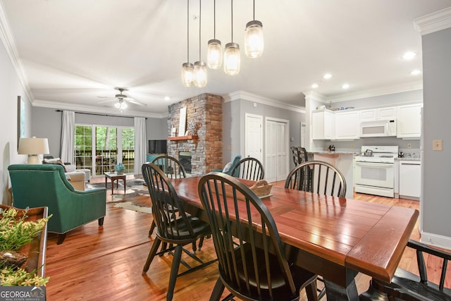 112 Gleneagle Ct Unit D202, Clayton, GA 30525 - dining area with crown molding, ceiling fan, a fireplace, light wood-style floors, and recessed lighting