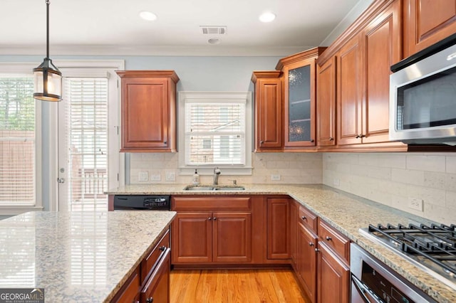 4503 Kendall Way, Roswell, GA 30075 - kitchen with stainless steel appliances, a sink, light stone counters, light wood-type flooring, and crown molding