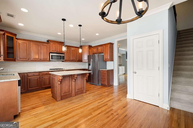 4503 Kendall Way, Roswell, GA 30075 - kitchen with stainless steel appliances, brown cabinets, ornamental molding, a sink, and a center island