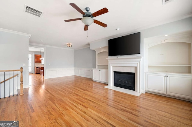 4503 Kendall Way, Roswell, GA 30075 - unfurnished living room featuring ornamental molding, ceiling fan, light wood-style floors, a fireplace with flush hearth, and a wainscoted wall