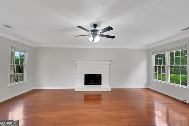 4009 Riverstone Dr, Suwanee, GA 30024 - unfurnished living room featuring plenty of natural light, wood finished floors, ornamental molding, ceiling fan, and a fireplace