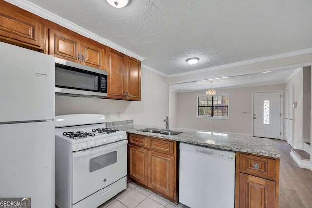 6991 Flagstone Dr, Austell, GA 30168 - kitchen with white appliances, a peninsula, brown cabinets, light stone counters, and ornamental molding