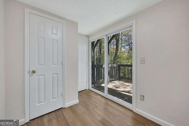 6991 Flagstone Dr, Austell, GA 30168 - unfurnished bedroom with access to exterior, wood finished floors, and a textured ceiling