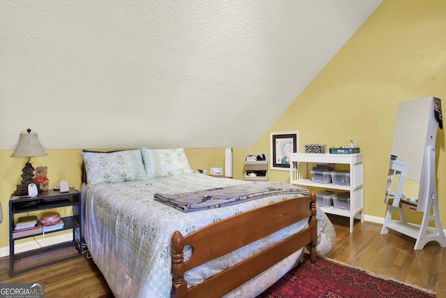 404 Carruth Rd, Winder, GA 30680 - bedroom with wood finished floors, a textured ceiling, vaulted ceiling, and baseboards