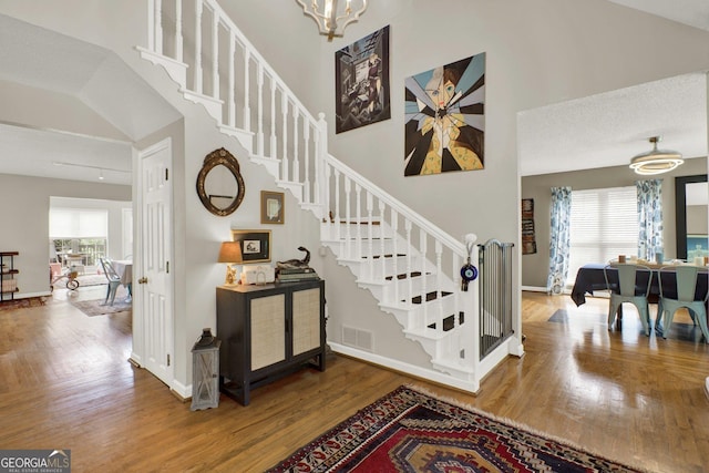 404 Carruth Rd, Winder, GA 30680 - staircase featuring wood finished floors, a towering ceiling, a chandelier, and baseboards