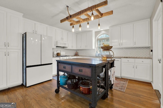 404 Carruth Rd, Winder, GA 30680 - kitchen featuring freestanding refrigerator, white cabinetry, tasteful backsplash, and wood finished floors