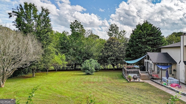 404 Carruth Rd, Winder, GA 30680 - view of green lawn featuring a wooden deck and view of wooded area