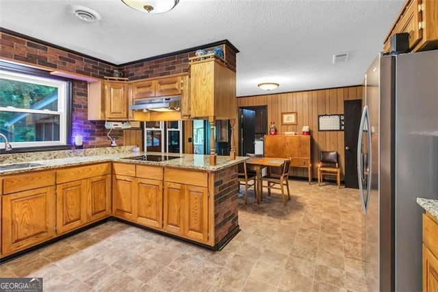 190 Roberts Way, Cornelia, GA 30531 - kitchen with freestanding refrigerator, under cabinet range hood, a peninsula, black electric stovetop, and brown cabinetry