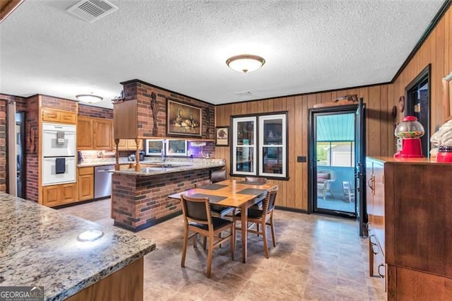 190 Roberts Way, Cornelia, GA 30531 - kitchen with dishwasher, white double oven, wooden walls, and a textured ceiling