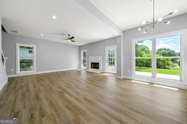 142 Arnco 3rd St, Newnan, GA 30263 - unfurnished living room featuring light wood-style flooring, a chandelier, baseboards, a high end fireplace, and recessed lighting