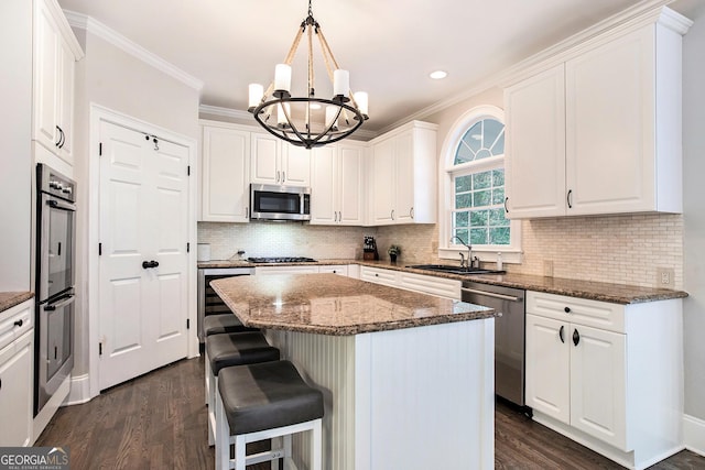 650 Garden Wilde Pl, Roswell, GA 30075 - kitchen with appliances with stainless steel finishes, a sink, a chandelier, dark wood-style floors, and crown molding