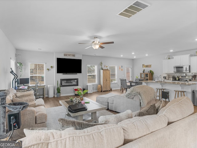 445 Sawmill Trce, Hampton, GA 30228 - living area featuring light wood-type flooring, a ceiling fan, recessed lighting, and baseboards