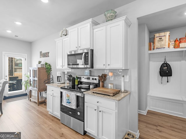445 Sawmill Trce, Hampton, GA 30228 - kitchen with stainless steel appliances, light wood-style flooring, light stone countertops, white cabinets, and recessed lighting