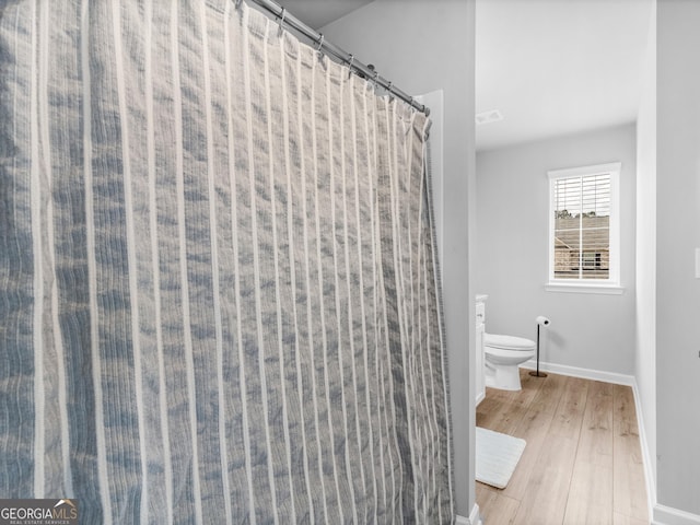 445 Sawmill Trce, Hampton, GA 30228 - full bathroom featuring toilet, wood finished floors, baseboards, and a shower with curtain