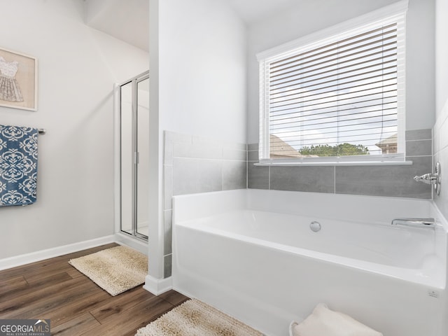 445 Sawmill Trce, Hampton, GA 30228 - bathroom with a bath, wood finished floors, a shower stall, and baseboards