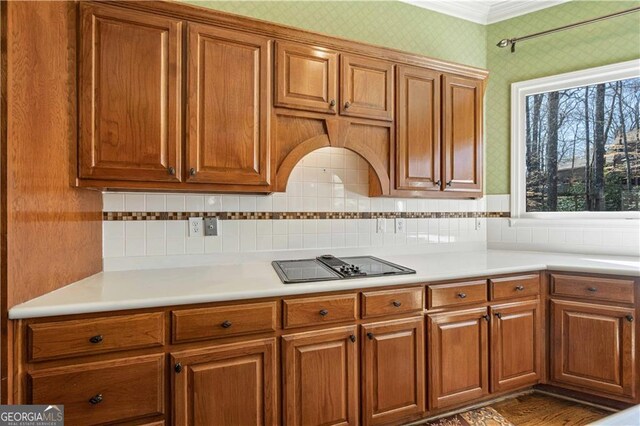 3410 Kates Way, Duluth, GA 30097 - kitchen with wallpapered walls, black electric stovetop, brown cabinets, and crown molding
