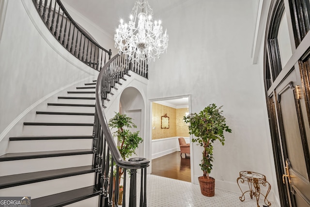 2878 Heather Row Rdg SW, Lilburn, GA 30047 - stairway with a high ceiling, a chandelier, baseboards, and ornamental molding