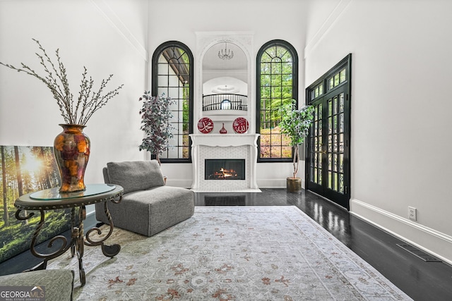 2878 Heather Row Rdg SW, Lilburn, GA 30047 - sitting room with a lit fireplace, baseboards, dark wood-type flooring, and a towering ceiling