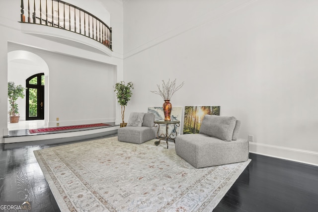 2878 Heather Row Rdg SW, Lilburn, GA 30047 - sitting room featuring arched walkways, dark wood finished floors, a high ceiling, and baseboards
