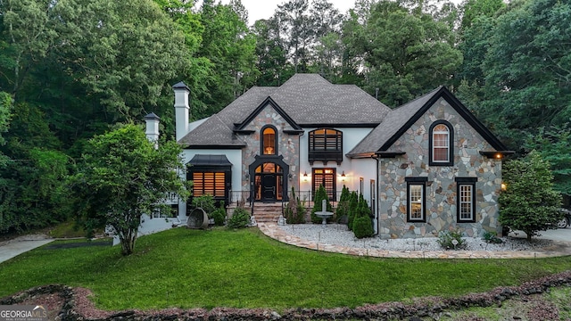 2878 Heather Row Rdg SW, Lilburn, GA 30047 - french country style house with a front lawn, stone siding, a chimney, and a shingled roof