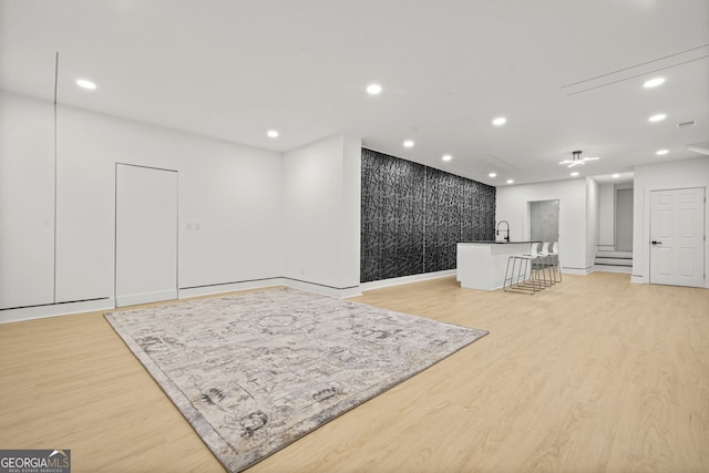 2878 Heather Row Rdg SW, Lilburn, GA 30047 - unfurnished living room featuring light wood-style floors, recessed lighting, baseboards, and bar