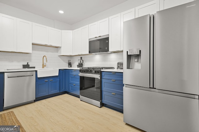 2878 Heather Row Rdg SW, Lilburn, GA 30047 - kitchen featuring stainless steel appliances, a sink, blue cabinetry, light countertops, and recessed lighting