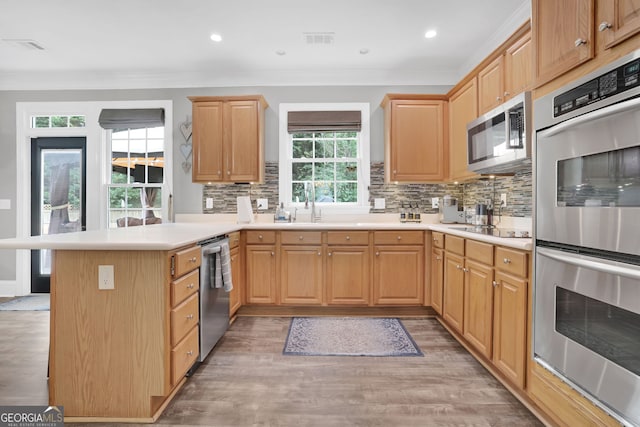 285 Finsbury Park Ct, Suwanee, GA 30024 - kitchen with appliances with stainless steel finishes, a peninsula, backsplash, crown molding, and light countertops
