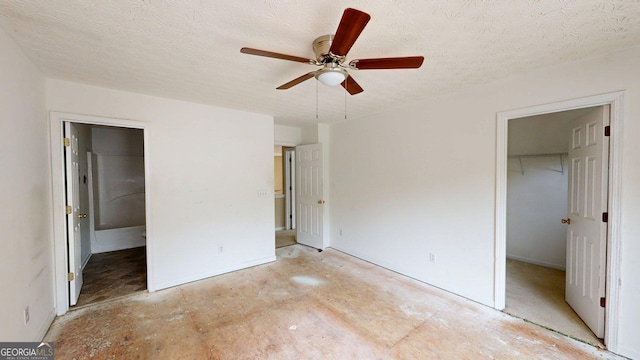176 Silver Fox Trl, Dallas, GA 30157 - unfurnished bedroom featuring a spacious closet, a closet, a textured ceiling, and ceiling fan