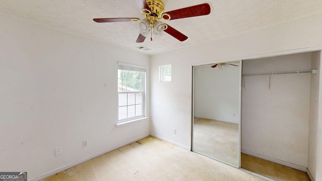 176 Silver Fox Trl, Dallas, GA 30157 - unfurnished bedroom with a closet, a textured ceiling, baseboards, a ceiling fan, and light carpet
