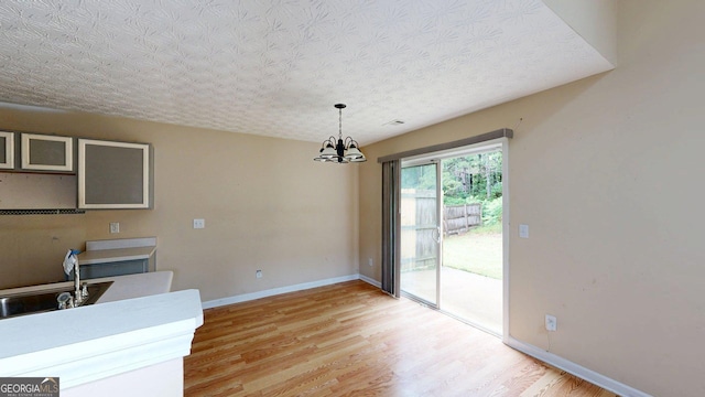 176 Silver Fox Trl, Dallas, GA 30157 - kitchen featuring a chandelier, light wood-style flooring, baseboards, and decorative light fixtures
