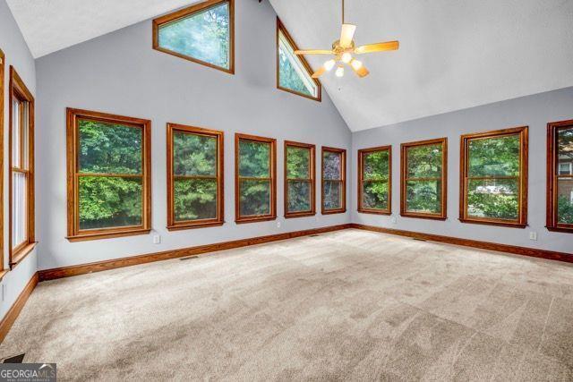 362 Clyde Ct, Mcdonough, GA 30252 - carpeted spare room with high vaulted ceiling, a ceiling fan, and baseboards