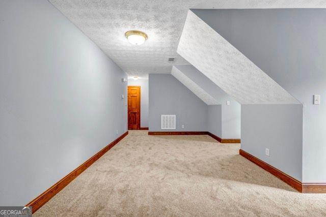 362 Clyde Ct, Mcdonough, GA 30252 - bonus room with carpet flooring, a textured ceiling, and baseboards