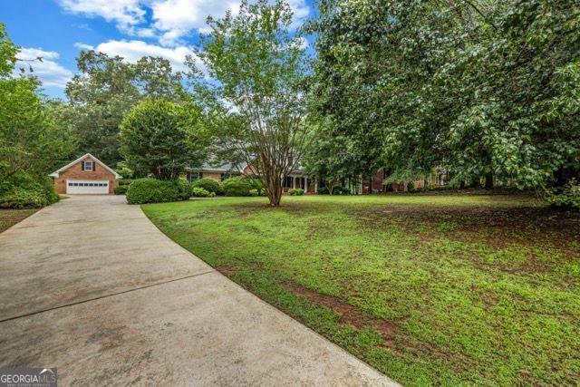 362 Clyde Ct, Mcdonough, GA 30252 - view of green lawn with a detached garage and driveway