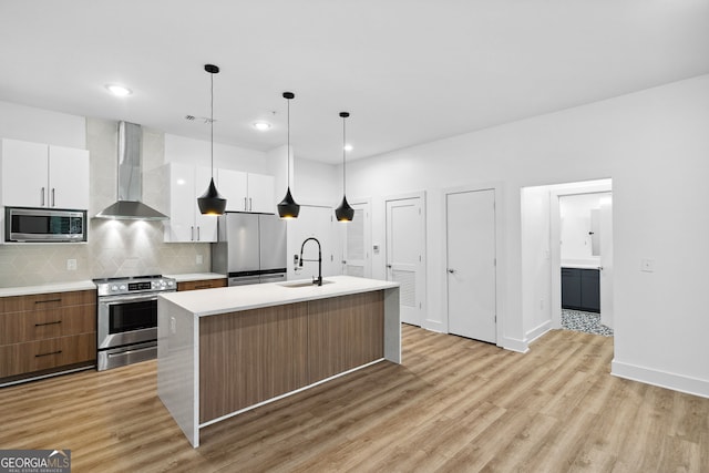 112 Rogers St NE Unit 304, Atlanta, GA 30317 - kitchen featuring stainless steel appliances, wall chimney range hood, modern cabinets, a sink, and light wood finished floors