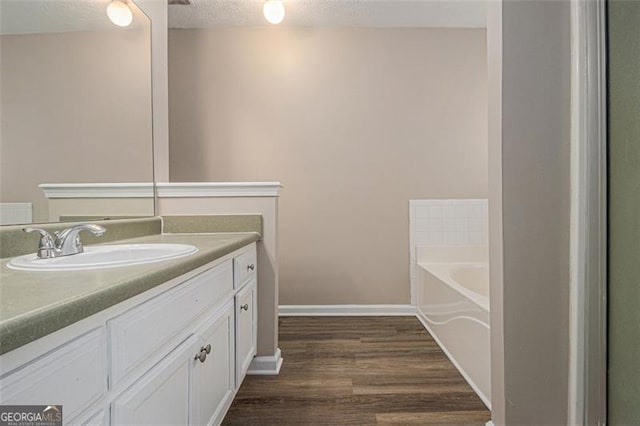 1501 Buckingham Pl, Stockbridge, GA 30281 - full bathroom featuring wood finished floors, vanity, a bath, and a textured ceiling