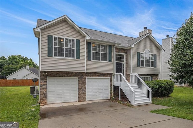1501 Buckingham Pl, Stockbridge, GA 30281 - split foyer home with an attached garage, a front lawn, concrete driveway, stone siding, and a chimney