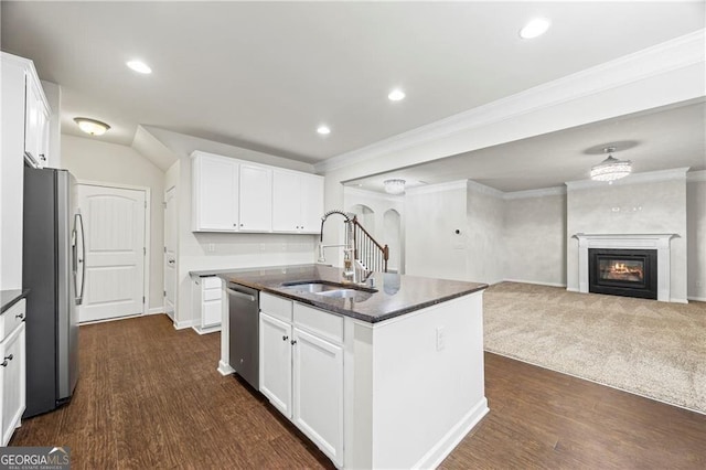 303 Orange Cir, Dawsonville, GA 30534 - kitchen with stainless steel appliances, a sink, open floor plan, crown molding, and a glass covered fireplace