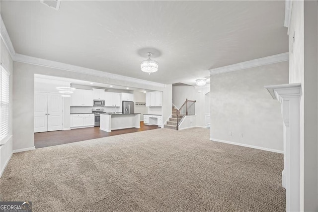 303 Orange Cir, Dawsonville, GA 30534 - unfurnished living room featuring dark colored carpet, crown molding, stairway, and baseboards